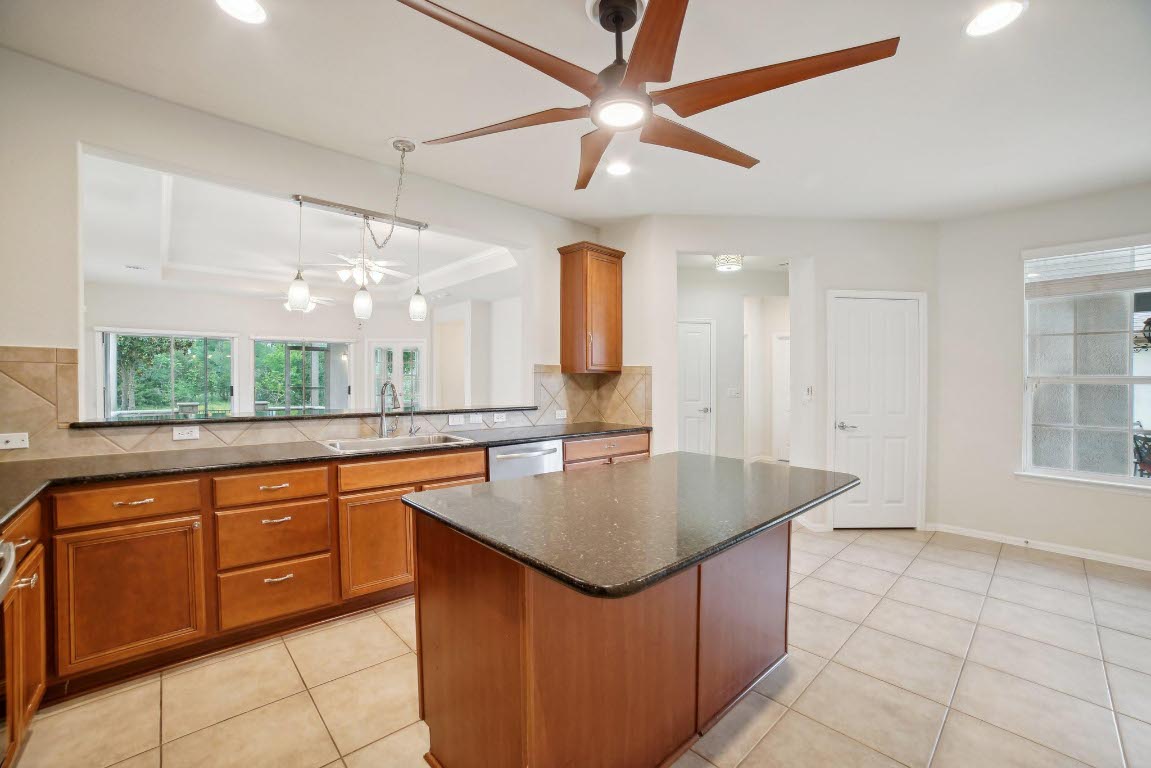 207 Trinity Lane Georgetown, TX 78633 - Photo 7 of 37 a large kitchen with kitchen island a large counter space a sink appliances and a window