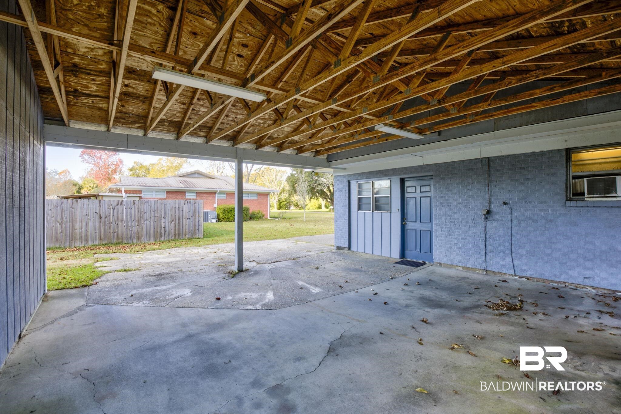 606 East Myrtle Avenue Foley, AL 36535 - Photo 18 of 24 Garage featuring cooling unit and a lawn
