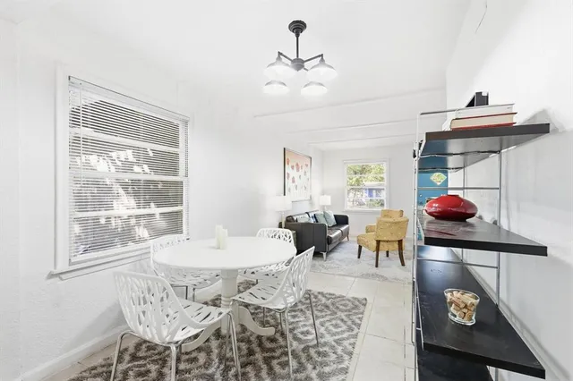 a living room with dining table and a chandelier