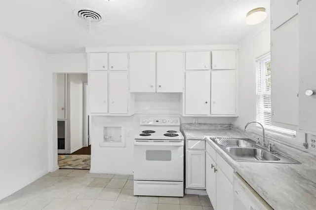 a kitchen with white cabinets sink and white appliances