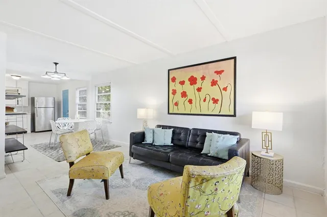 a living room with furniture and a painting on the wall