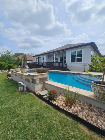 a swimming pool with outdoor seating and yard