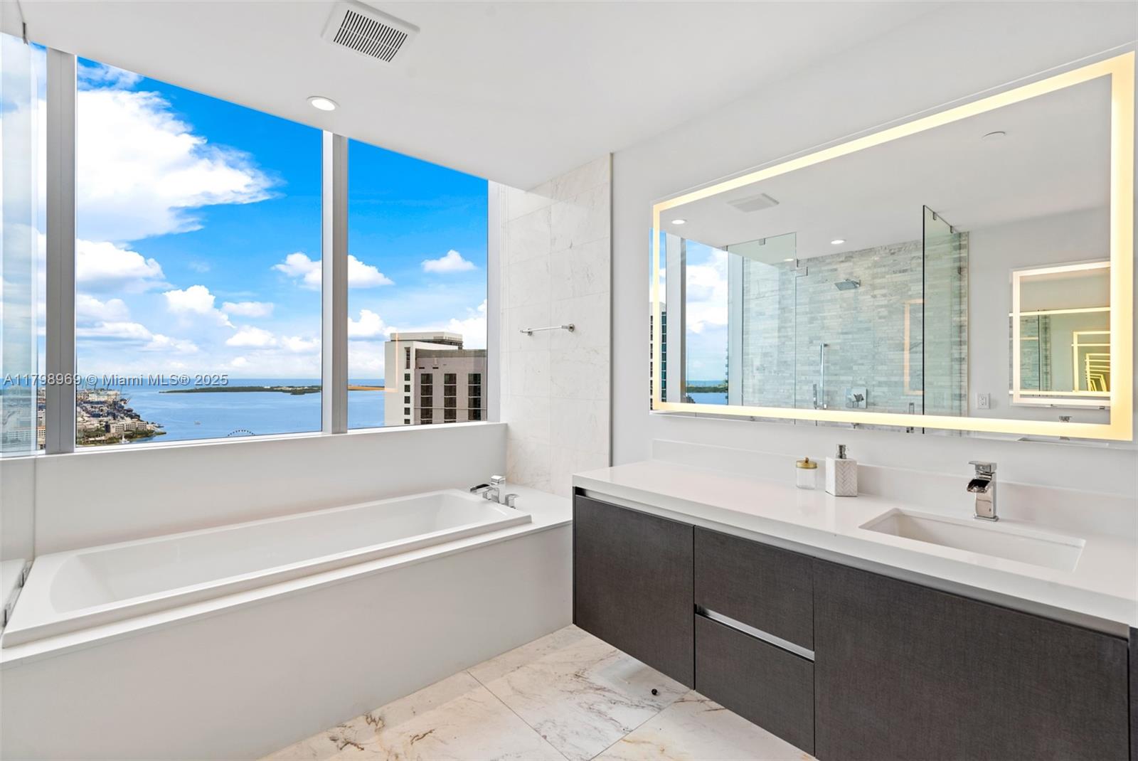 851 Northeast 1st Avenue, Unit 4011 Miami, FL 33132 - Photo 14 of 37 a bathroom with a bathtub a double vanity sink and mirror