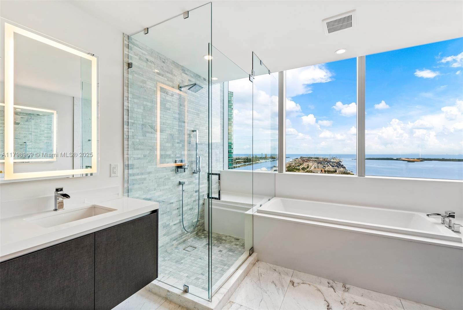 851 Northeast 1st Avenue, Unit 4011 Miami, FL 33132 - Photo 15 of 37 a bathroom with a double vanity sink and a tub