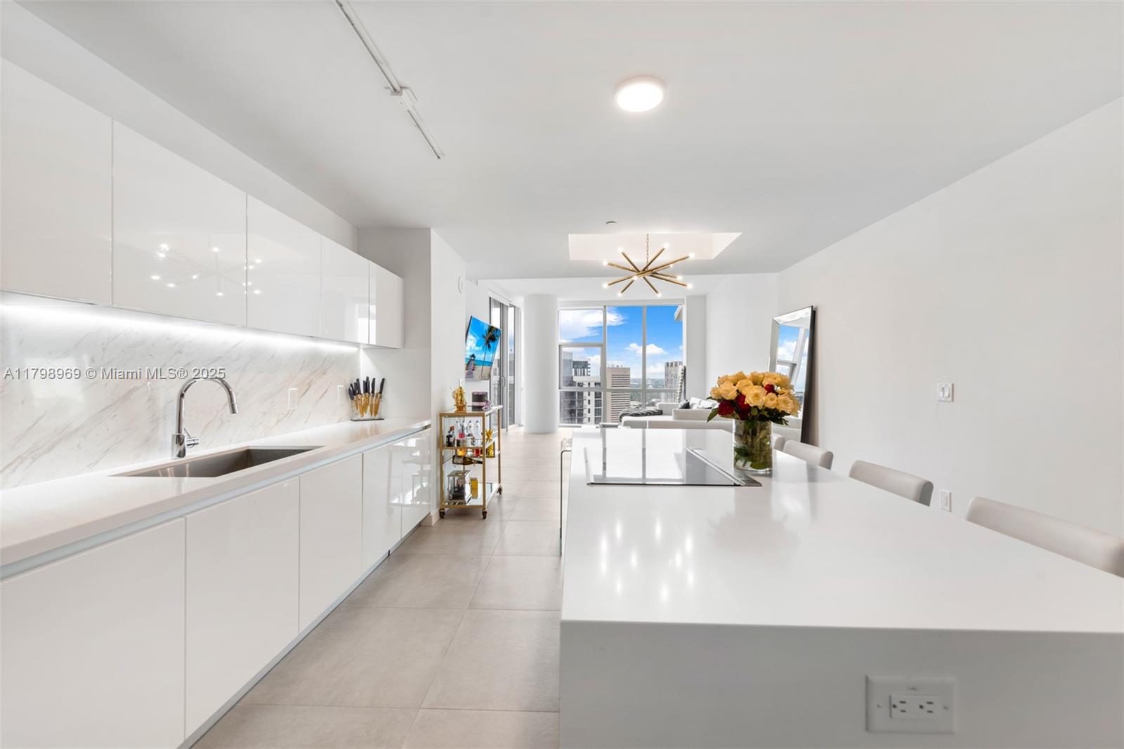 851 Northeast 1st Avenue, Unit 4011 Miami, FL 33132 - Photo 19 of 37 a large white kitchen with a sink and dishwasher a stove top oven with wooden floor