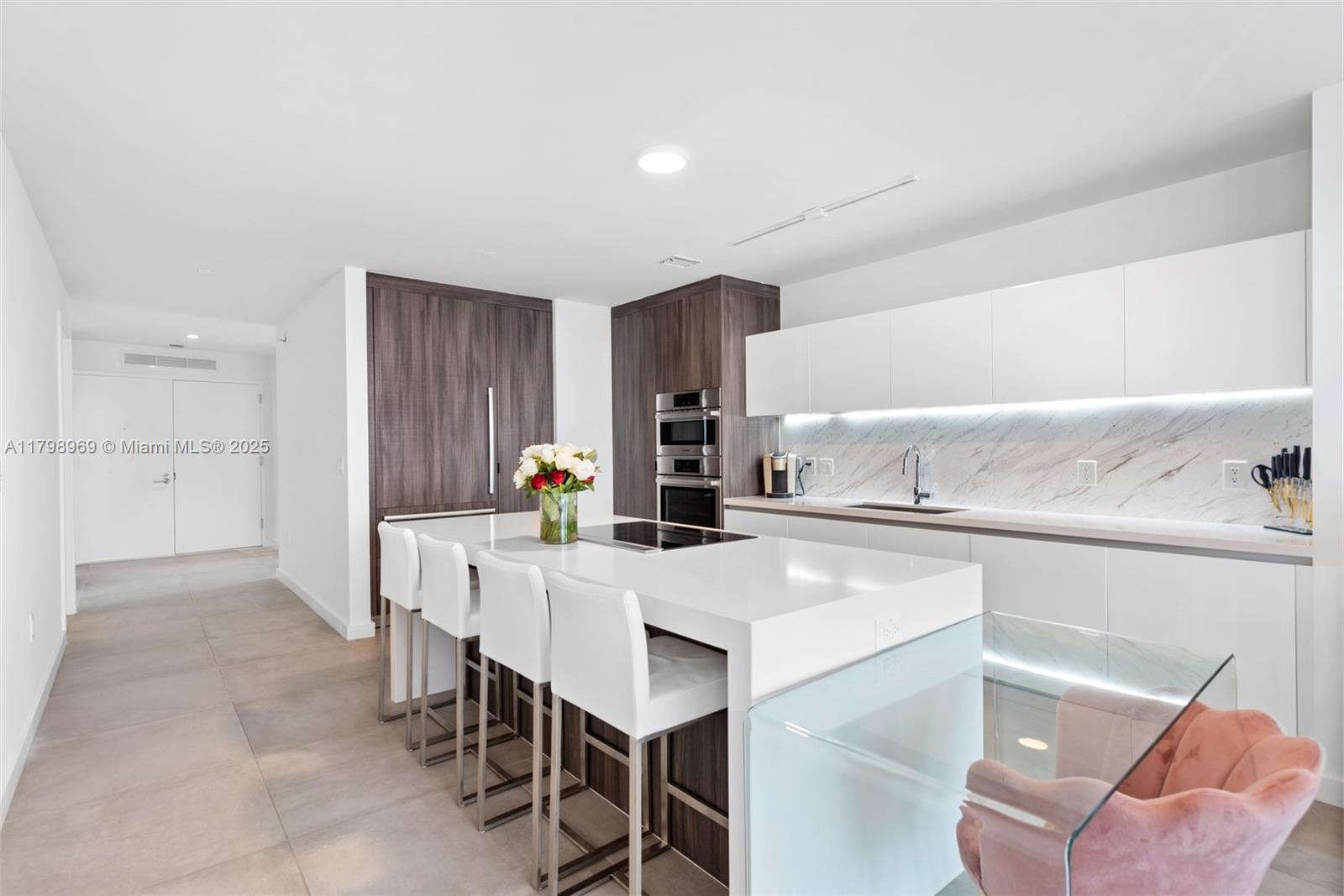851 Northeast 1st Avenue, Unit 4011 Miami, FL 33132 - Photo 20 of 37 a kitchen with a dining table chairs and refrigerator