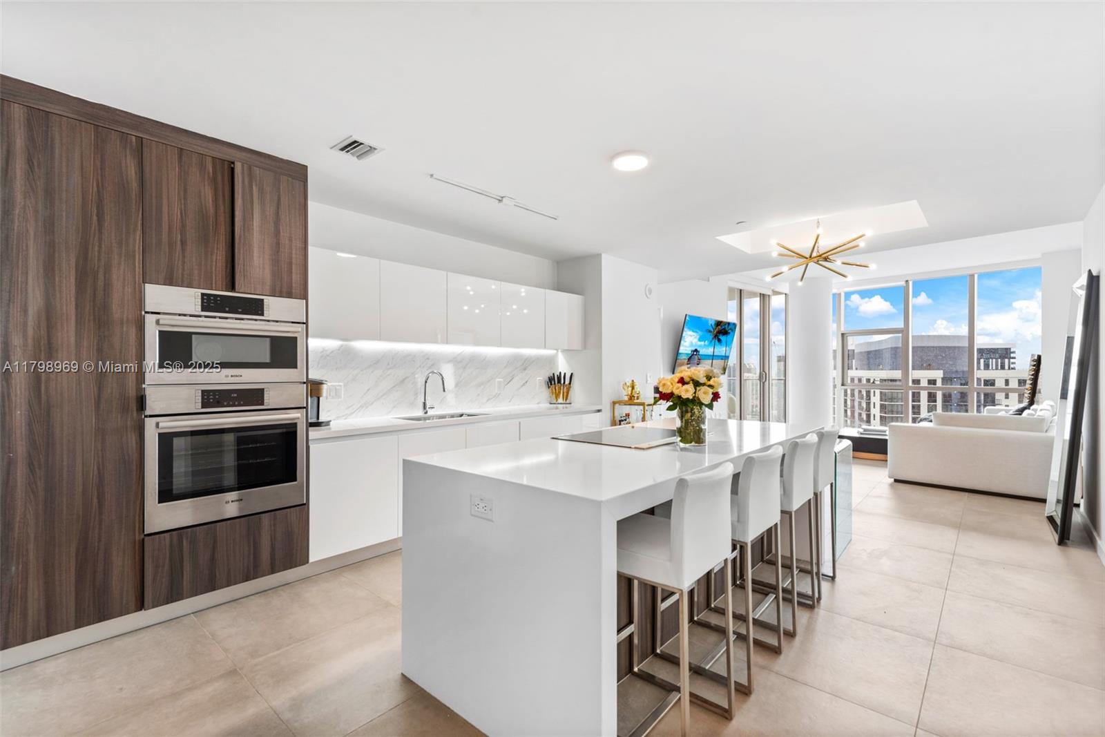 851 Northeast 1st Avenue, Unit 4011 Miami, FL 33132 - Photo 3 of 37 a kitchen with stainless steel appliances kitchen island granite countertop a stove top oven a sink with island and chairs