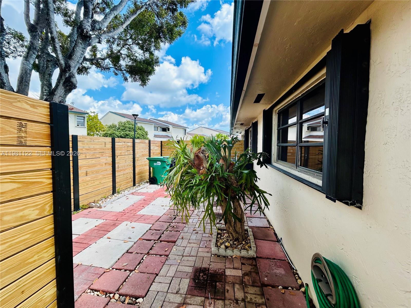 10818 Southwest 72nd Street, Unit 154 Miami, FL 33173 - Photo 12 of 28 a vase of flowers sitting on a floor in front of a building