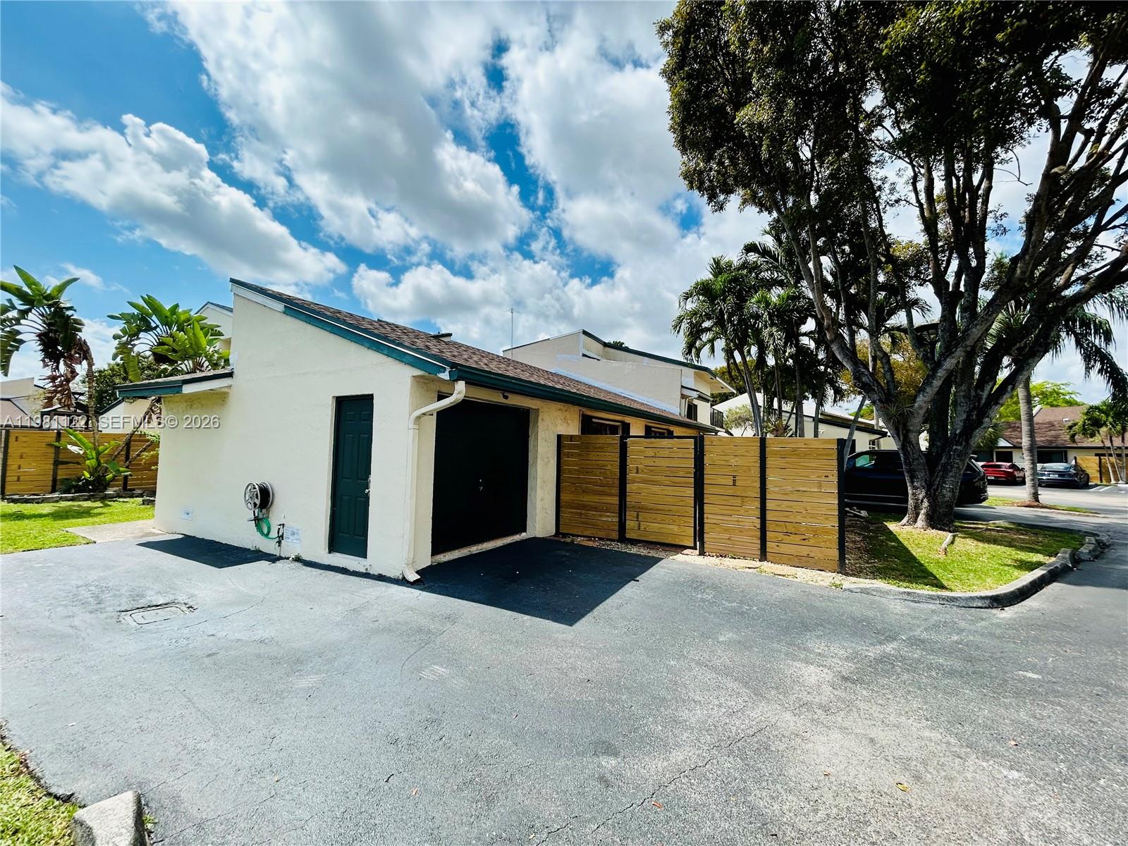 10818 Southwest 72nd Street, Unit 154 Miami, FL 33173 - Photo 2 of 28 a view of a house with basketball yard and large tree