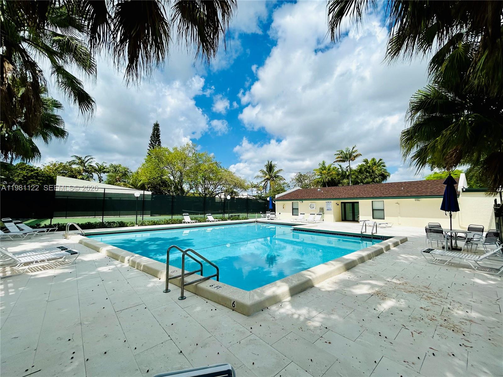 10818 Southwest 72nd Street, Unit 154 Miami, FL 33173 - Photo 24 of 28 a view of a house with swimming pool and a yard