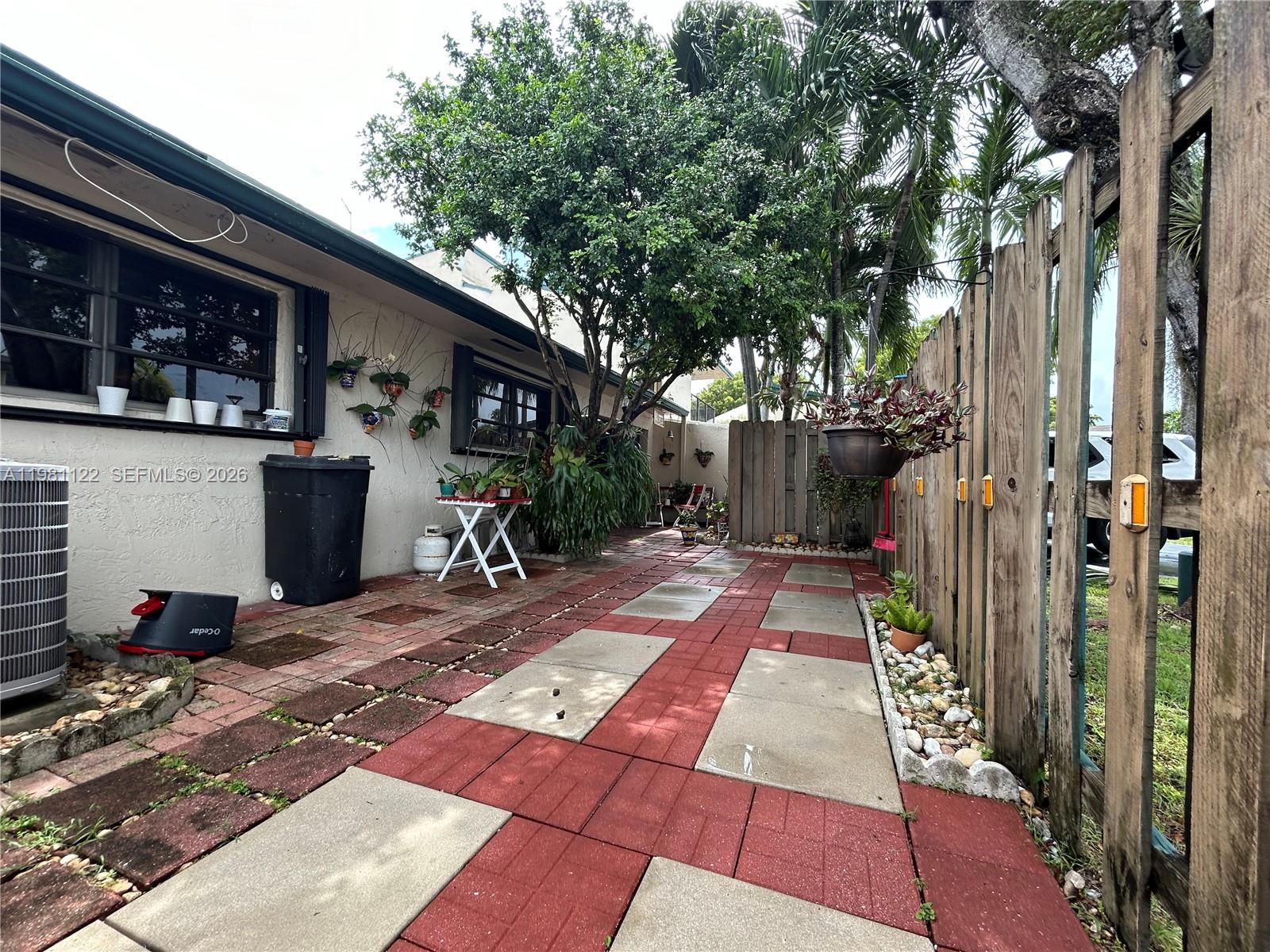 10818 Southwest 72nd Street, Unit 154 Miami, FL 33173 - Photo 10 of 28 a view of a patio with table and chairs potted plants and a large tree