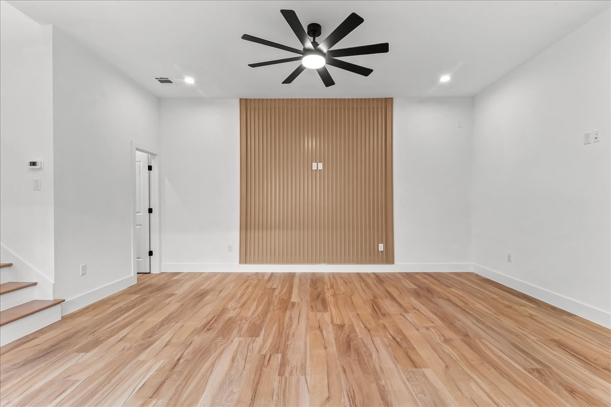 8323 Observatory Street, Unit A/B Houston, TX 77088 - Photo 16 of 38 Unit B - Upon entry, you’ll be welcomed by a spacious living room featuring a stunning accent wall that beautifully complements the flooring, creating a warm and cohesive design. Recessed lighting and a modern ceiling fan enhance the space, providing both style and comfort while filling the room with a bright, inviting atmosphere.Accent Wall design may vary. Pictures are from a previous build.