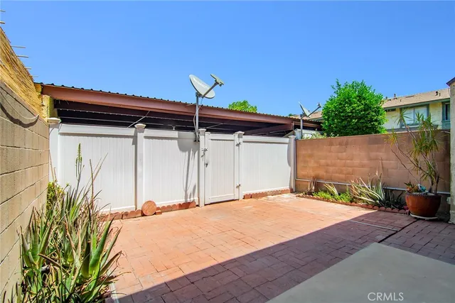 a backyard of a house with table and chairs a fire pit and potted plants