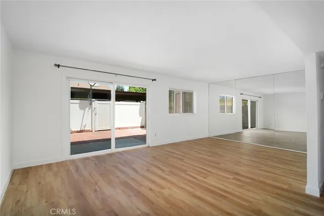 a view of empty room with wooden floor and window