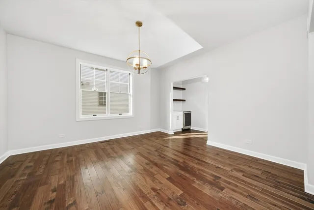 a view of empty room with wooden floor and window