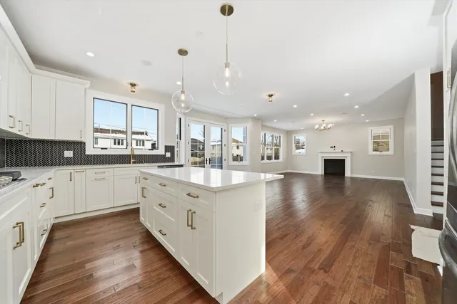 a kitchen with white cabinets stainless steel appliances and wooden floor