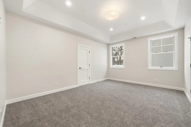 an empty room with windows and white walls