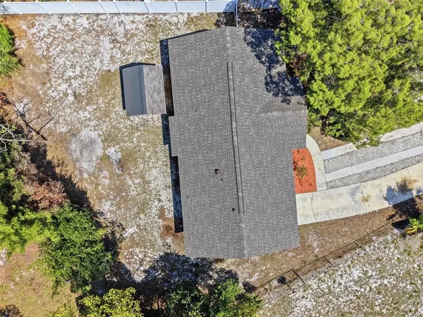 a view of a white house with a yard and potted plants