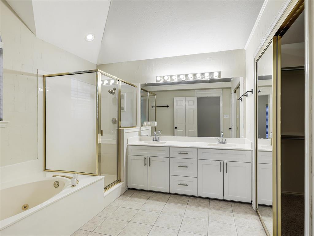 7836 Tournament Road Frisco, TX 75035 - Photo 15 of 23 Dual vanity with undermount sinks, separate shower enclosure, built-in bathtub, mirrored closet doors, and tile flooring