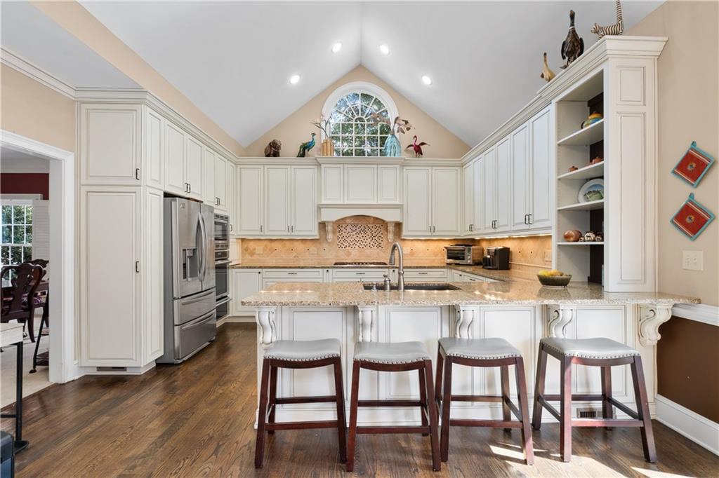 3613 Greystone Circle Chamblee, GA 30341 - Photo 16 of 53 a kitchen with stainless steel appliances granite countertop a stove a refrigerator and a dining table with wooden floor
