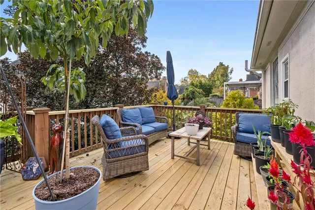 a balcony with wooden floor table and chairs