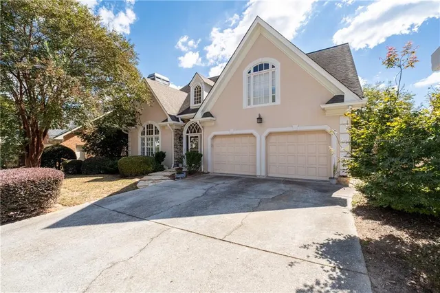 a view of a white house with a yard and large tree