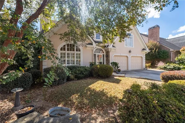 a front view of a house with yard and green space