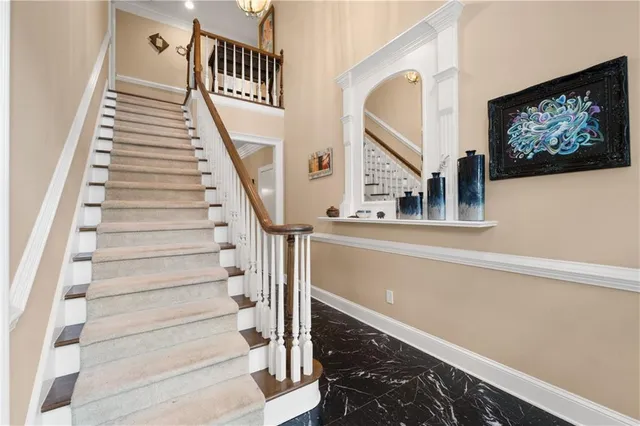 a view of staircase with lots of frames on wall and a black umbrella