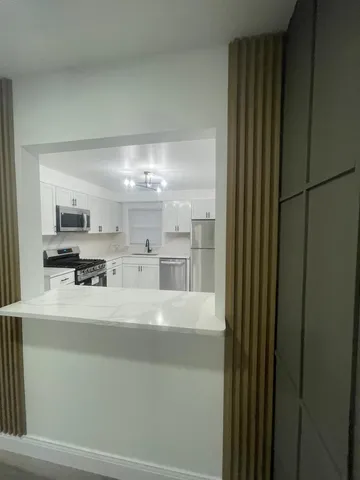 a view of a kitchen with refrigerator and windows