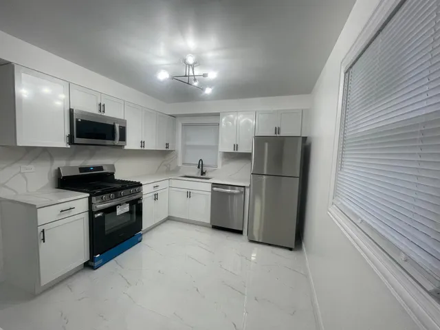 a kitchen with a refrigerator a microwave and cabinets