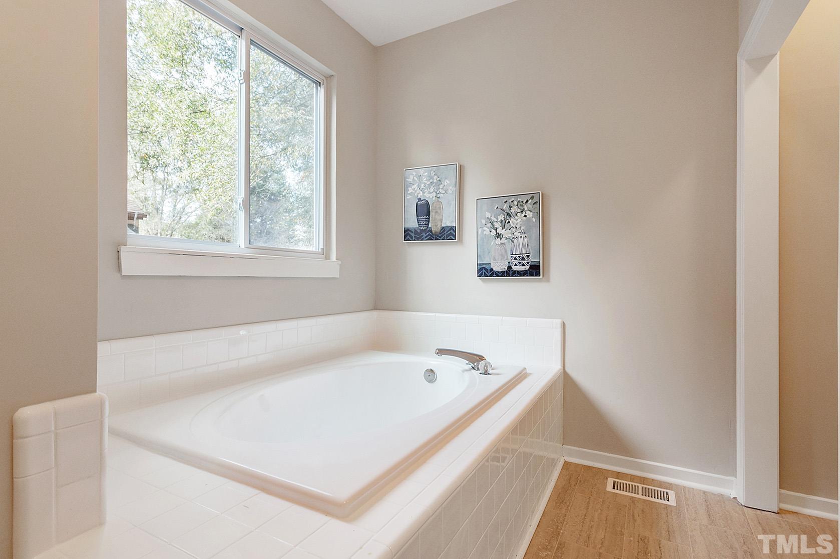 1904 Carthage Circle Raleigh, NC 27604 - Photo 20 of 25 a white bath tub sitting in a bathroom next to a window