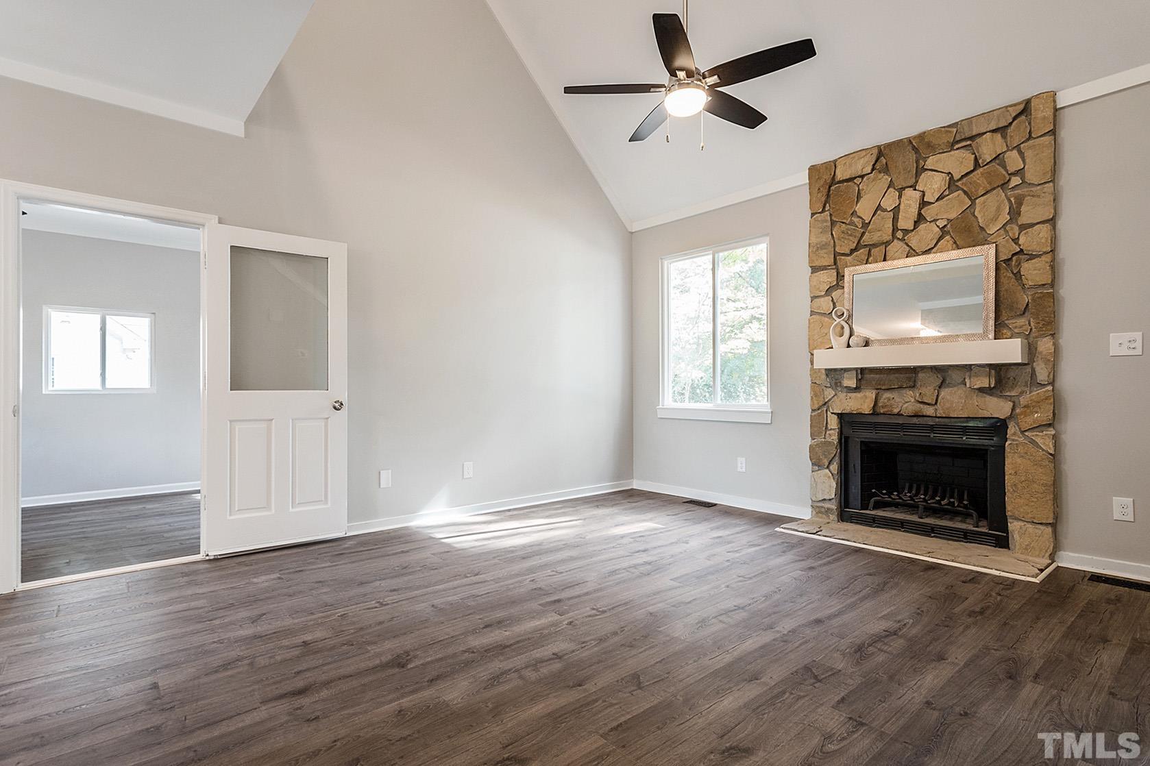 1904 Carthage Circle Raleigh, NC 27604 - Photo 3 of 25 an empty room with windows fireplace and wooden floor