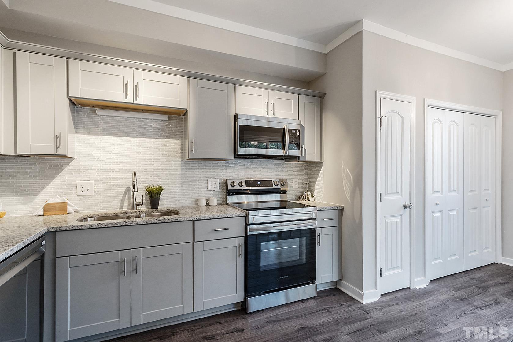 1904 Carthage Circle Raleigh, NC 27604 - Photo 7 of 25 a kitchen with cabinets stainless steel appliances a sink and wooden floor