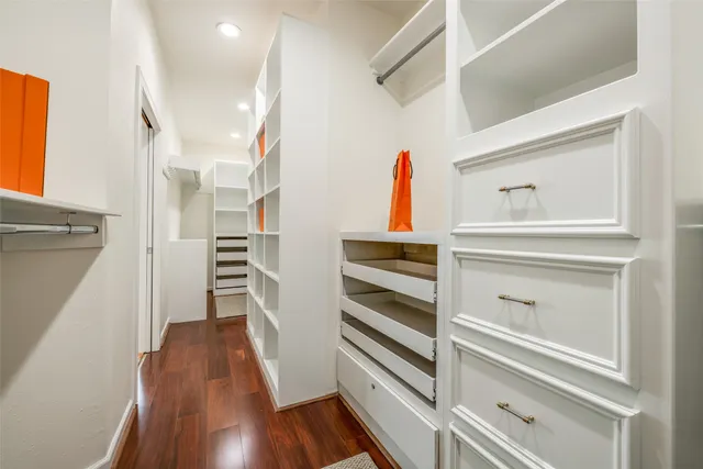 a view of walk in closet with clothes and shoes