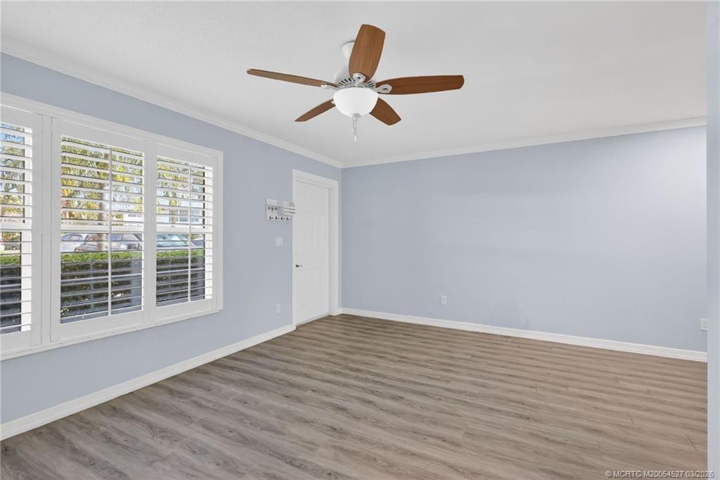 2929 Southeast Ocean Boulevard, Unit J3 Stuart, FL 34996 - Photo 12 of 65 a view of empty room with wooden floor and fan