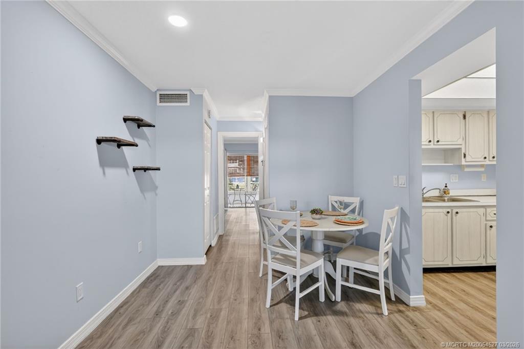 2929 Southeast Ocean Boulevard, Unit J3 Stuart, FL 34996 - Photo 13 of 65 a dining room with furniture and wooden floor