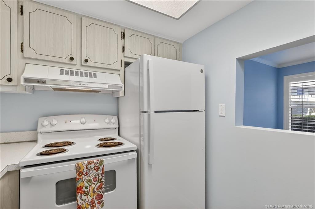 2929 Southeast Ocean Boulevard, Unit J3 Stuart, FL 34996 - Photo 18 of 65 a kitchen with a refrigerator a stove a washer and dryer