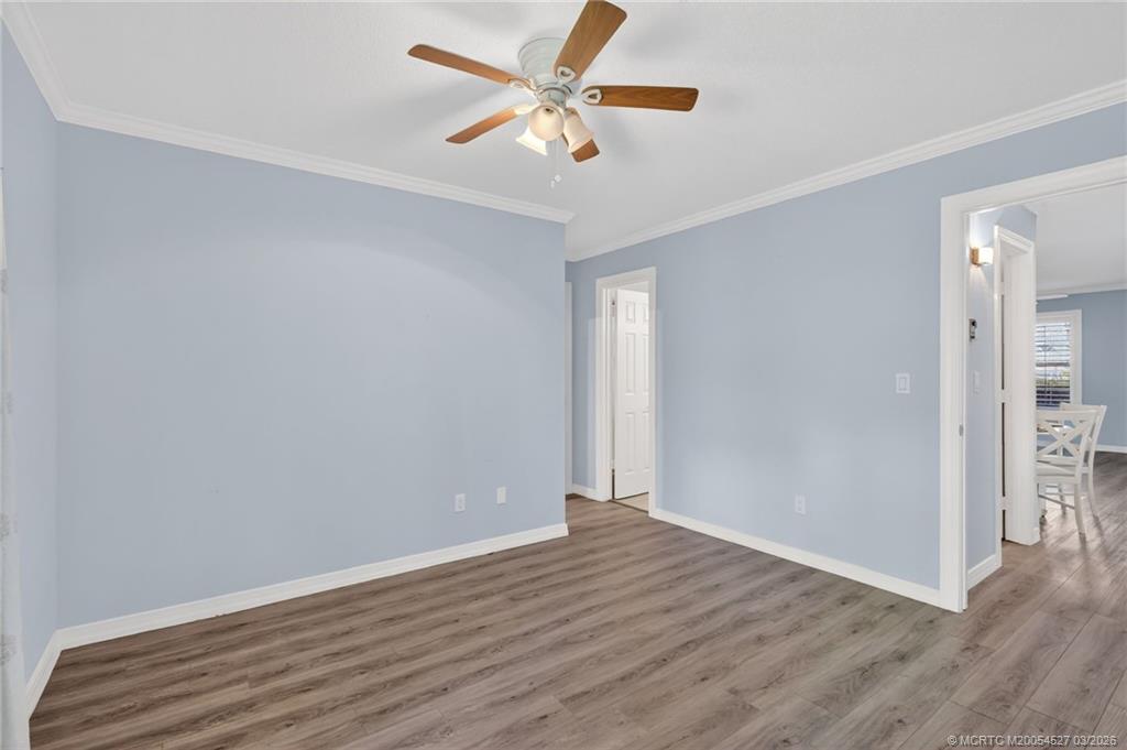 2929 Southeast Ocean Boulevard, Unit J3 Stuart, FL 34996 - Photo 25 of 65 an empty room with wooden floor and a ceiling fan