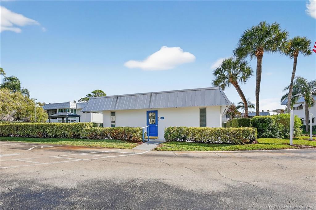 2929 Southeast Ocean Boulevard, Unit J3 Stuart, FL 34996 - Photo 38 of 65 a front view of a house with a yard and potted plants