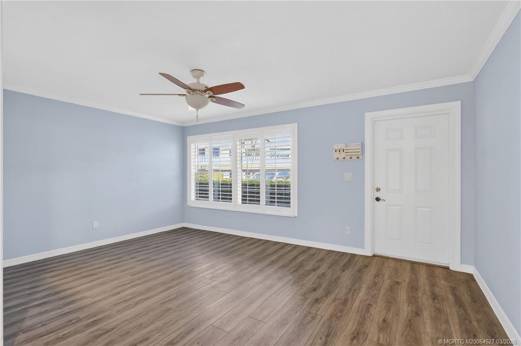 2929 Southeast Ocean Boulevard, Unit J3 Stuart, FL 34996 - Photo 9 of 65 a view of a room with wooden floor and a ceiling fan