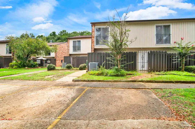 a front view of a house with a yard and potted plants