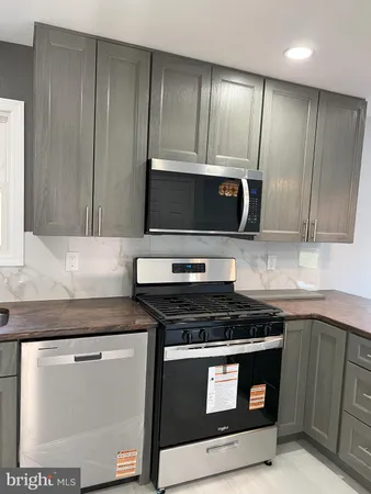 a kitchen with granite countertop white cabinets and black appliances