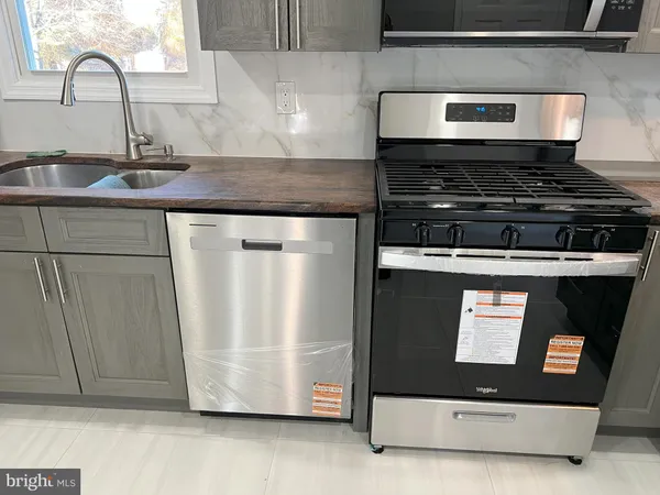a kitchen with stainless steel appliances granite countertop a sink and a refrigerator