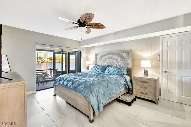 a spacious bedroom with a large bed and a chandelier