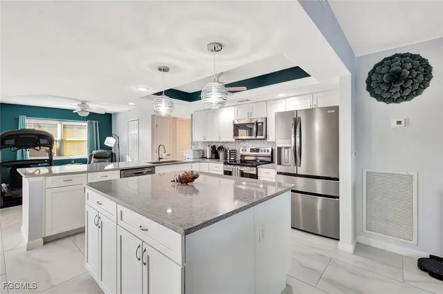 a kitchen with a sink a refrigerator and cabinets