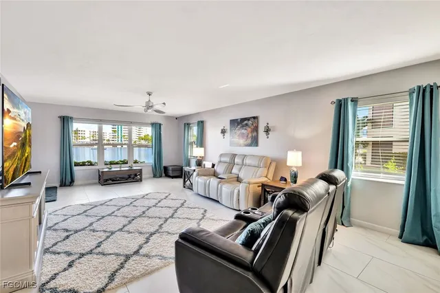 a living room with furniture large window and flat screen tv