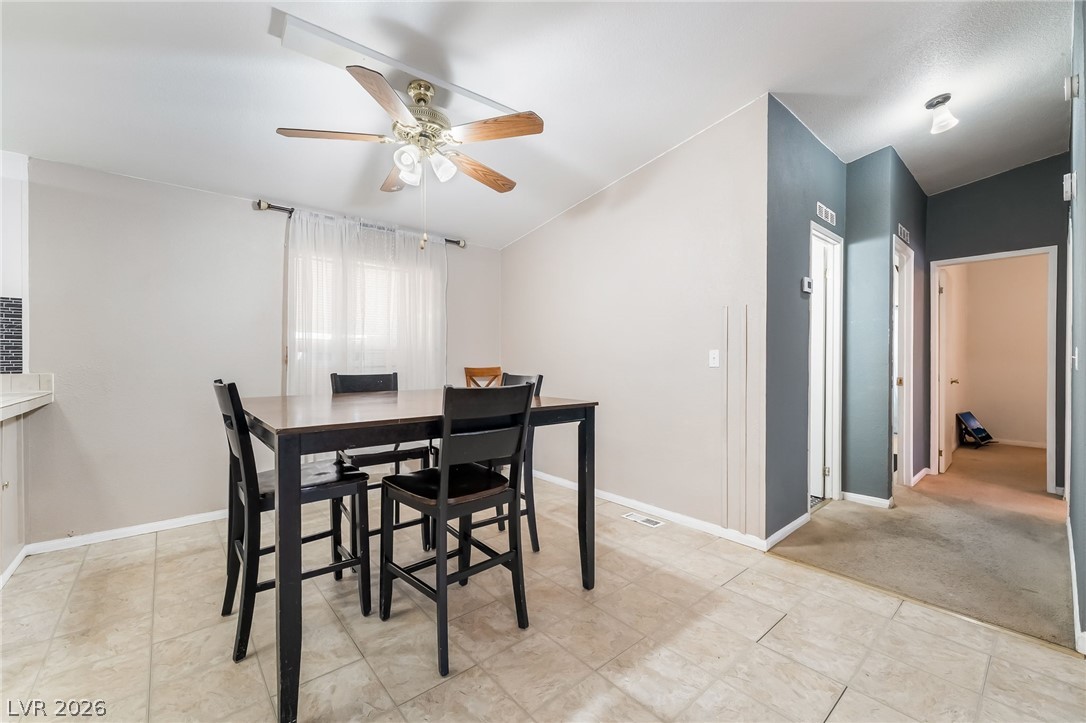 1551 West Wilson Road Pahrump, NV 89048 - Photo 13 of 68 Tiled flooring and neutral walls define this versatile dining space leading to adjacent hallways.
