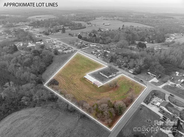 a view of a dry yard with wooden fence
