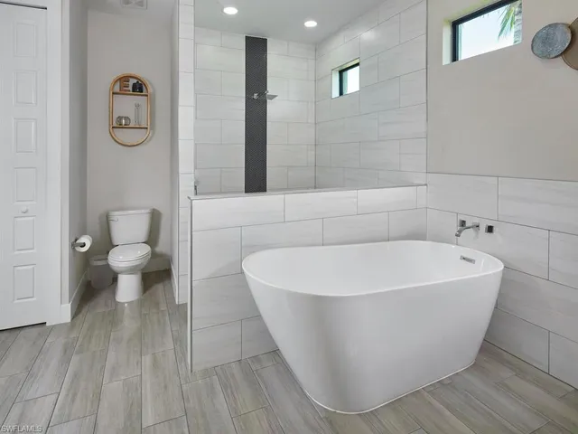 a white bath tub sitting next to a toilet