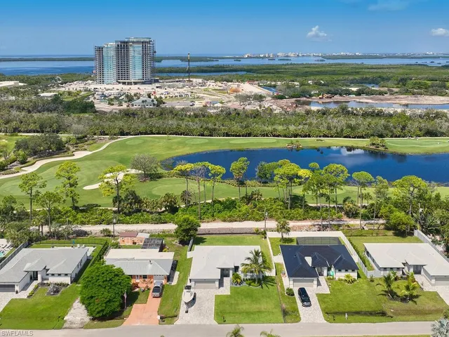 an aerial view of a city with lots of residential buildings ocean and mountain view in back